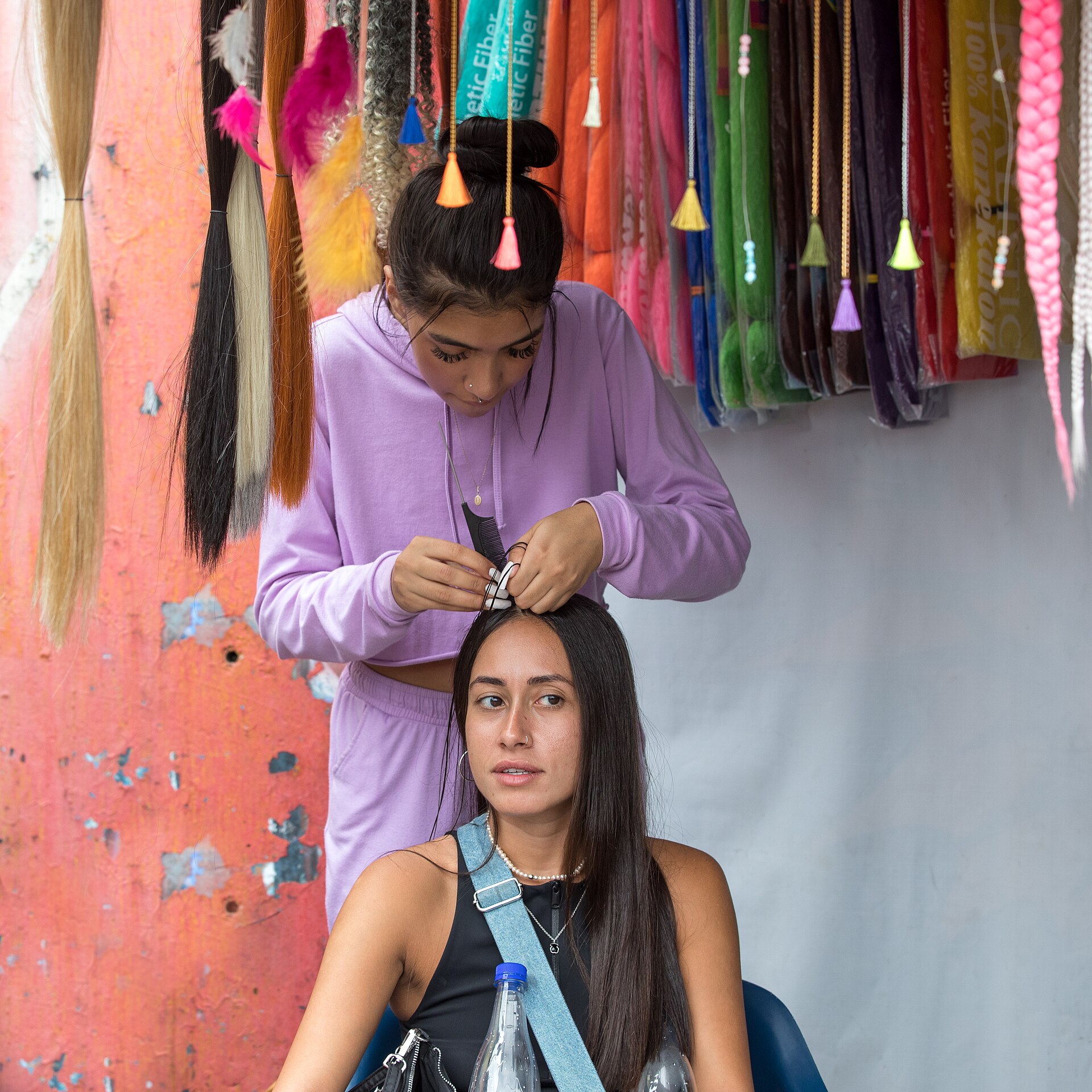 Hands braiding hair during a salon service