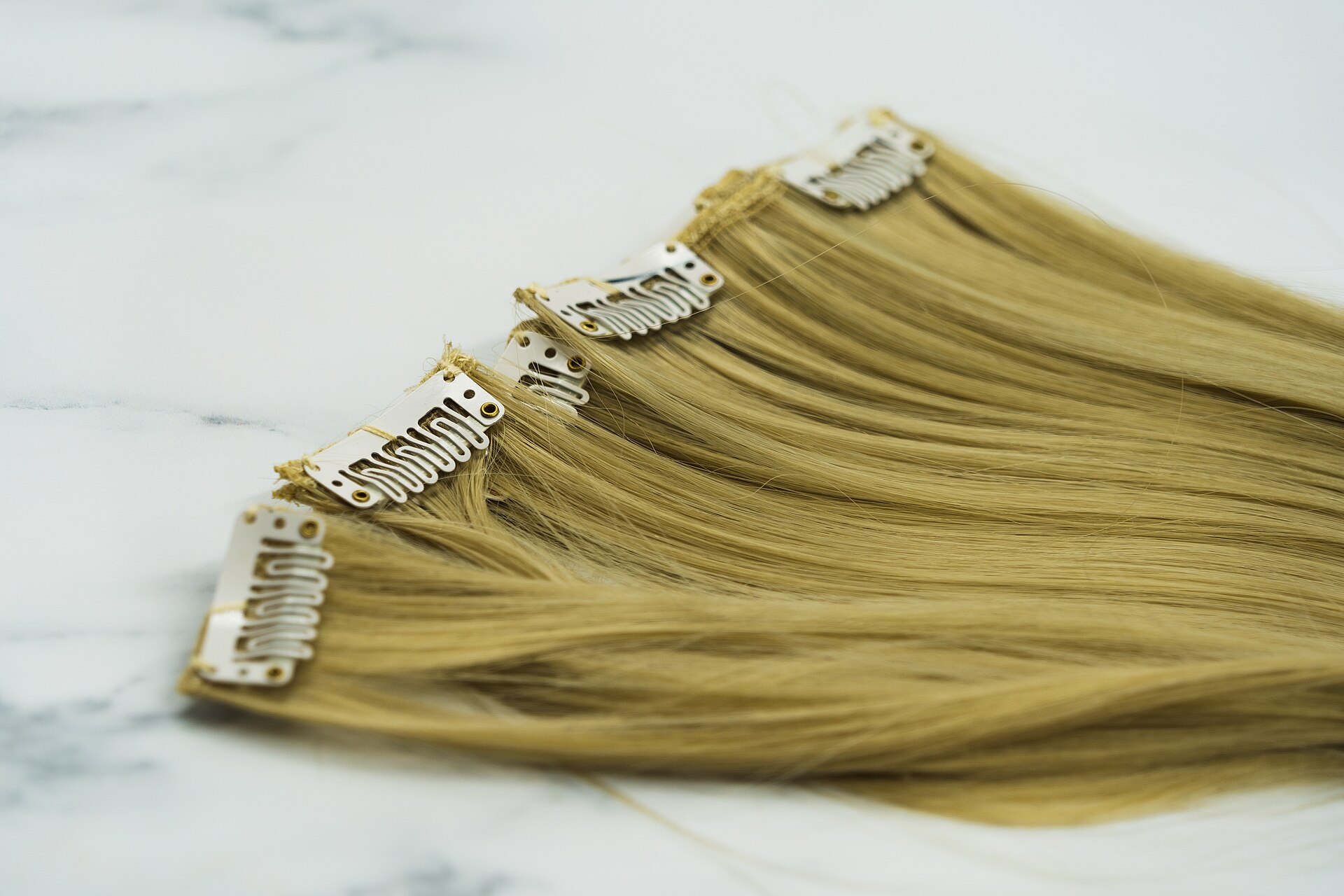 Clip-in human hair extensions laid out for inspection